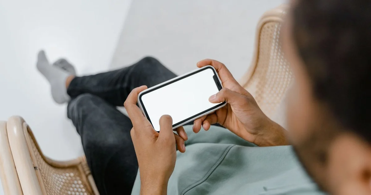 スマートフォンを横向きに持って画面を見る人