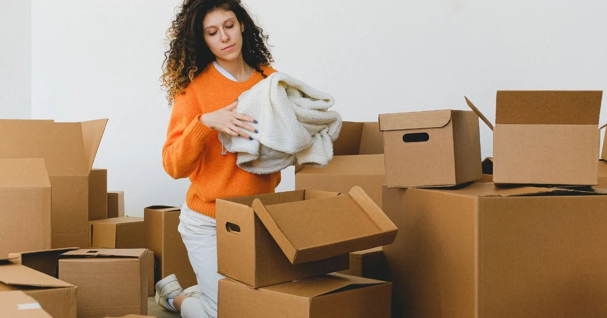 段ボール箱に荷物を詰める女性
