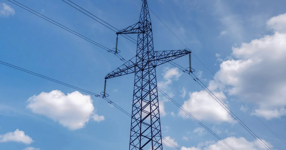 青空と雲を背景にした送電鉄塔と送電線